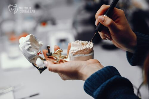 A skilled technician shaping a dental restoration by hand